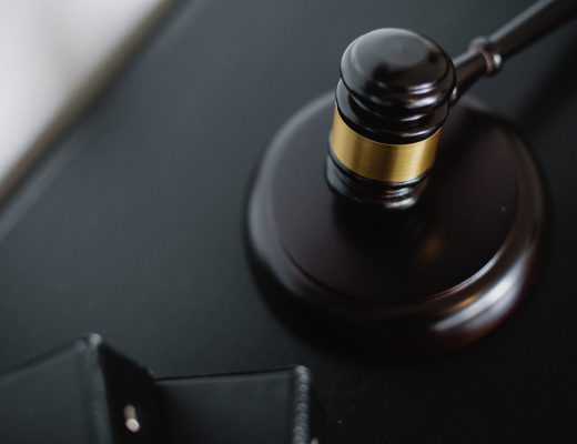 Imagem mostra uma mesa escura com um martelo e batente de juiz. A imagem representa a PL 6204/19 Execução